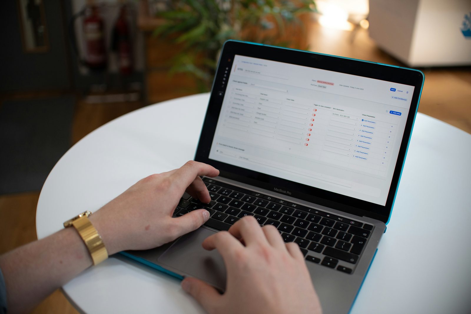 Hands typing on a laptop with a spreadsheet on screen